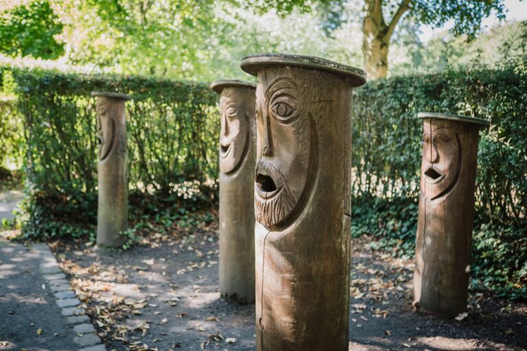 Holzstämme mit geschnitzten Gesichtern.