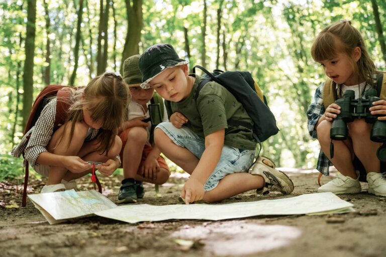 Kinder welche den Weg auf einer Karte suchen.